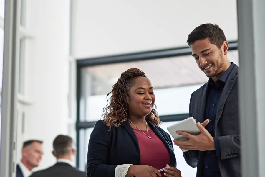 Une conseillère et un collègue qui consultent une tablette
