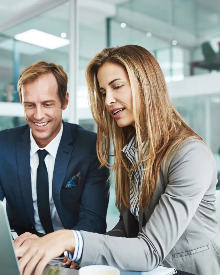 Deux professionnels qui travaillent ensemble devant un ordinateur portable