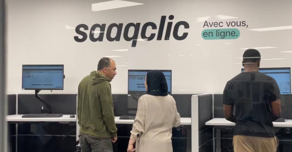 Clients devant les postes informatiques libre-service SAAQclic dans un centre de service de la SAAQ